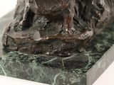 a statue of a dog sitting on a marble base