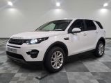 La Land Rover blanche est garée sur un sol carrelé à damier.