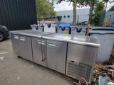 un tas de déchets par terre, à côté d'un réfrigérateur
