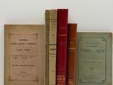 plusieurs vieux livres posés les uns sur les autres sur une surface blanche