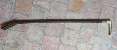 a large metal hammer on the ground next to a brick floor