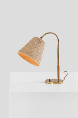 the table lamp is made of wood and has a beige fabric shade