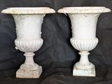 two white vases that are sitting on a black cloth