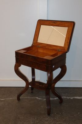 a small wooden table with a mirror on top of it