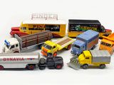 many toy trucks that are lined up together on a white surface