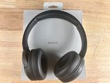 a pair of black headphones sitting on top of a wooden table