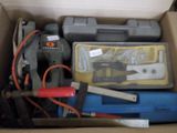 une boîte remplie d'outils posés sur le sol
