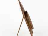 a wooden easel with a bird on it and a white background
