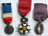 trois médailles et une médaille sur une surface blanche