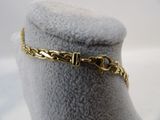 a close up of a gold chain bracelet on a mannequin