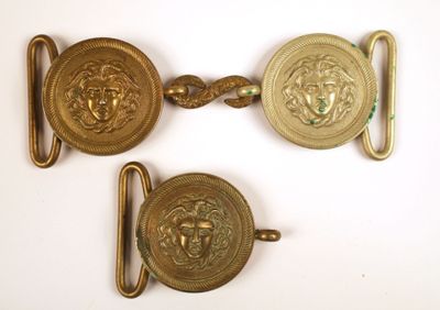 trois boucles de ceinture en laiton ornées de têtes de lion sur un fond blanc