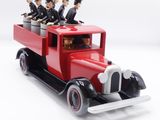 un camion jouet rouge avec plein de gens à l'intérieur