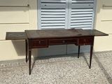 a table with a drawer on it sitting in front of a window