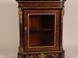 an image of a small cabinet with a black top and red and gold decoration