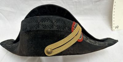 un chapeau noir orné d'un ruban doré