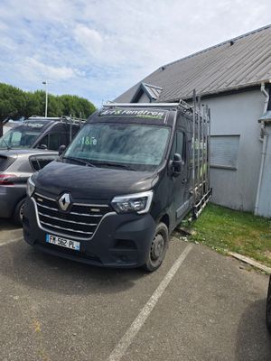 une camionnette noire garée sur un parking à côté d'un immeuble