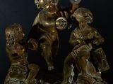 a bronze statue of a boy and two girls playing with a ball