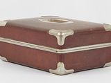 a small brown suitcase sitting on top of a white surface