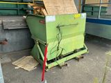 a green dumpster sitting in the middle of a parking lot