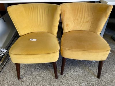 deux chaises jaunes placées l'une à côté de l'autre sur un sol recouvert de moquette