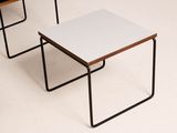 three small tables with black legs and a white top sit on a white floor