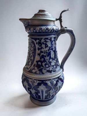 a blue and white vase with a lid on a table