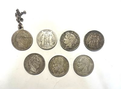 several coins are arranged in a row on a white surface