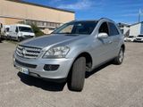 Le SUV argenté est garé sur un parking près d'un immeuble.