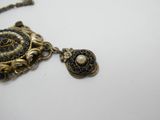 une photo en gros plan d'un collier posé sur une surface blanche