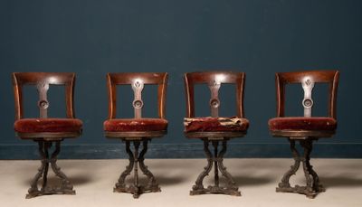 trois chaises en bois aux assises rembourrées de rouge, devant un mur bleu