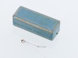 une petite boîte bleue surmontée d'une chaîne