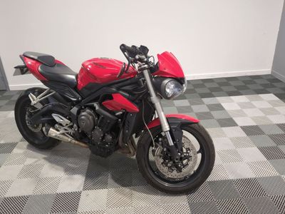 une moto rouge garée sur un sol à damier
