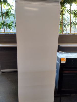 a white refrigerator sitting in a room next to a window