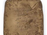 an old piece of cloth with writing on it on a white surface