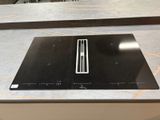 une plaque de cuisson noire posée sur un plan de travail dans une cuisine