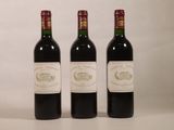 trois bouteilles de vin rouge posées côte à côte sur une table
