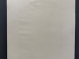 une feuille de papier blanche accrochée à un mur noir