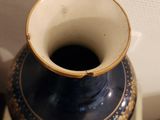 a blue vase sitting on top of a wooden table