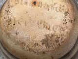 a brown pot with writing on it sitting on the ground
