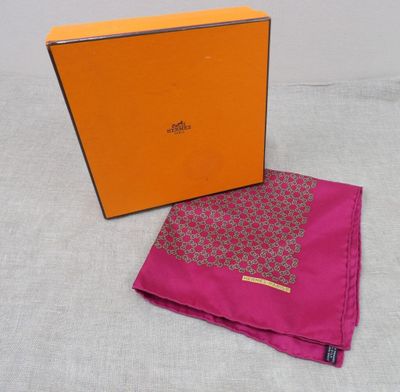 an orange box with a pink scarf and a pink handkerchief on a table
