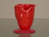 un vase rouge posé sur une table en verre