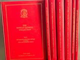 six livres rouges sont alignés sur une table
