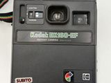 a polaroid camera sitting on a table with a strap around it