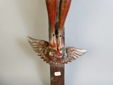a statue of a person on a cross with wings on it