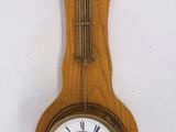 a wooden clock hanging on the wall with roman numerals