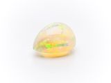 a white oplite stone with yellow and green speckles on it
