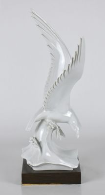 une image représentant une statue d'oiseau blanc posée sur un socle en bois