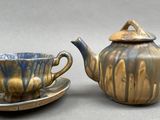 a tea pot and a cup on a saucer