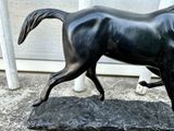 a statue of a horse that is standing on a base