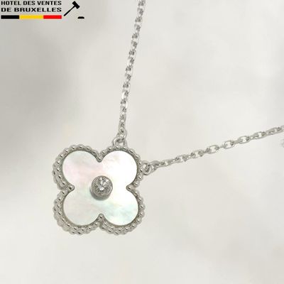 a close up of a necklace with a flower on a chain